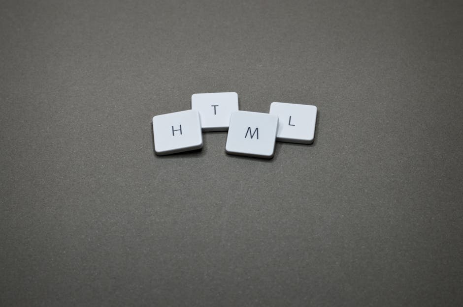 A close-up image of four small, white, rectangular tiles with smooth matte surfaces, arranged on a flat, dark grey background. Each tile displays a single black letter, together spelling out the word 